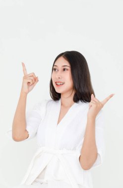 Asyalı siyah saçlı kadın modelin resim stüdyosu gülümsüyor kameraya bak boş fotokopi alanını işaret ediyor beyaz arka planda reklam ürünlerini gösteriyor.