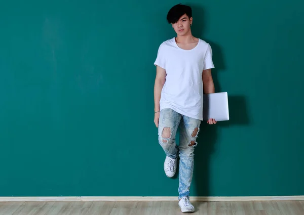 Позитивный Молодой Азиатский Студент Стоящий Стопкой Книг Студии Зеленом Фоне — стоковое фото