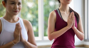 Kadın, Asya pozisyonunda yoga dersinde odaklanmış nefes alıyor. Huzurlu olun, rahatlayın, Zen konsantrasyonu. Bu temel duruş, iki eli avuç içi şeklinde birleştirerek yapılabilir.
