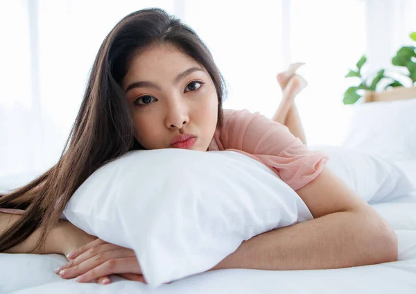 Beautiful young sensuality pretty Asian woman wearing red bra sleeping and  make happy smile on the white bed at bedroom in the morning. Stock Photo