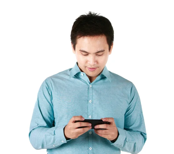 青シャツを着たアジア人男性がソーシャルメディアインターネットサービスマネージャーをしている携帯電話を持っています ハンサムな興奮陽気で楽しいです面白いです男使用して電話で白い背景 — ストック写真