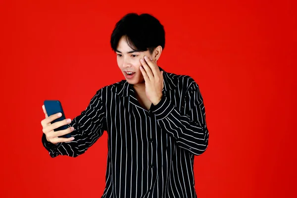 Азиатский Молодой Человек Трогает Лицо Держит Смартфон Правой Руке Сфотографировать — стоковое фото