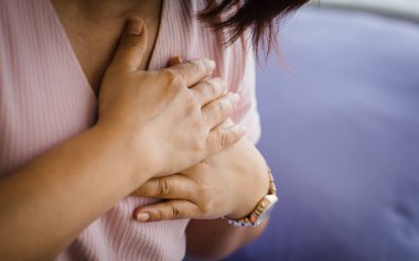 Kimliği belirlenemeyen yaşlı kadın yatakta oturuyor. Ani kalp krizinden muzdarip ve göğsünü tutuyor. Acil sağlık hizmeti kavramı ve kardiyopulmoner resüsitasyondan etkilenme, kalp sorunu.