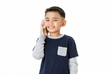 Gri kazak ve kot mavi tişörtlü sağlıklı Asyalı çocuğun hoş bir portresi. Mutlu sohbetler ve konforlu, kompakt, akıllı telefondan internet üzerinden eğlenceli sohbetler.