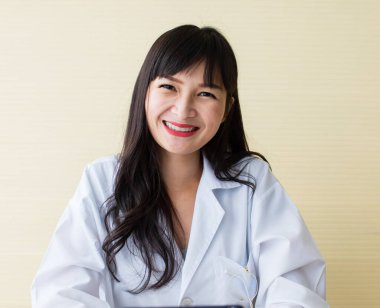 Asyalı güzel, uzun siyah saçlı güzel gözlü, beyaz takım elbiseli, kırmızı dudaklı. Gülümseyerek otur ve kameraya bak. Onun gülümsemesi neşeli insanlara yardımcı olur. Güvenilir, profesyonel, dost canlısı görünüyor.