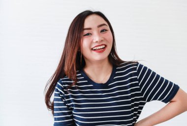 Asyalı genç, mutlu, neşeli, neşeli kadın modelin stüdyo portresi beyaz arka planda gülen günlük kıyafetler giyer..