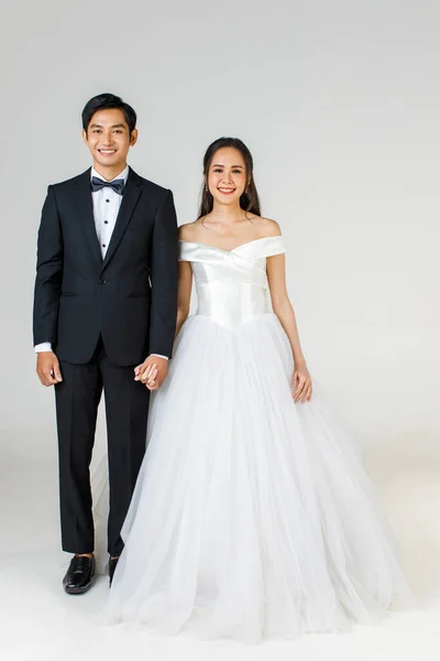 若い魅力的なアジアのカップルの完全な長さは すぐに花嫁と新郎 女性の白い結婚式のガウンを着ている 黒いタキシードを着た男が一緒に立っている 結婚式前の写真のコンセプト — ストック写真