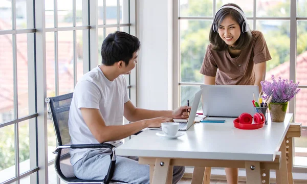 İç işlerinde dizüstü bilgisayar ve not defteri kullanarak proje üzerinde çalışan Asyalı genç işadamları rahat tişörtler giyiyorlar. Bu arada bayan kulaklıkla müzik dinliyor..