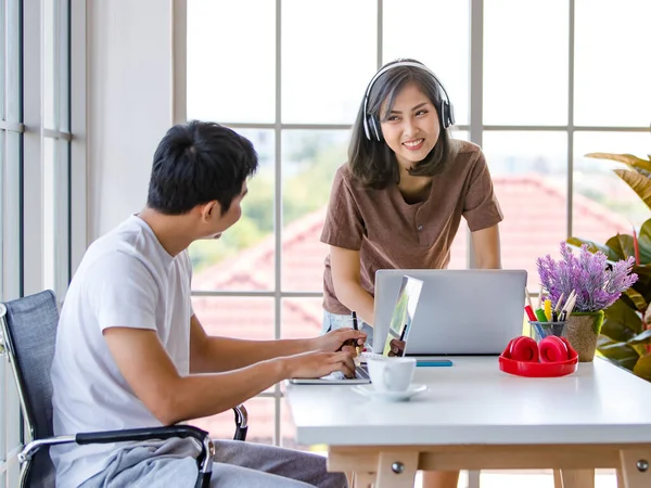 İç işlerinde dizüstü bilgisayar ve not defteri kullanarak proje üzerinde çalışan Asyalı genç işadamları rahat tişörtler giyiyorlar. Bu arada bayan kulaklıkla müzik dinliyor..