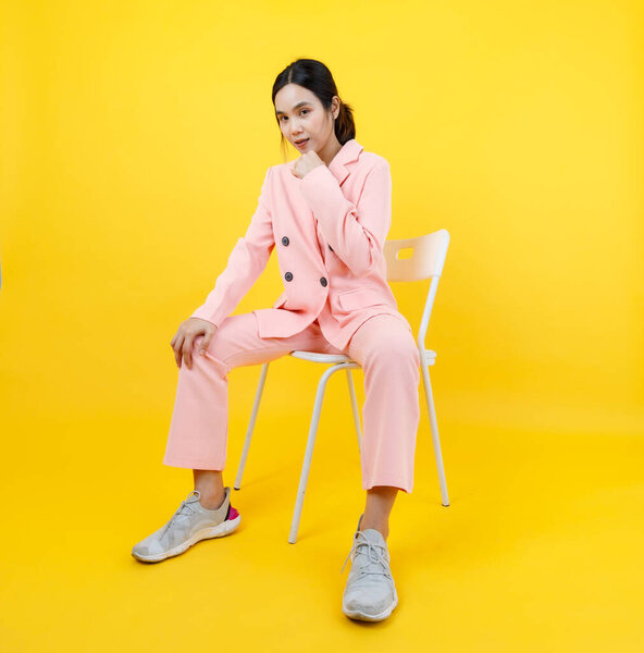 Прекрасная азиатская молодая девушка смеется и закрывает рот руками, как весело на позе удивительный жест с красивой розовой курткой для женской одежды моды. Взрослая модель выражает эмоции лица как неожиданность или шок.