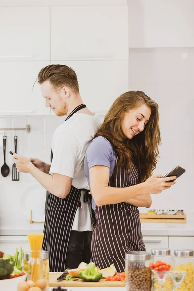 Delighted Couple Aprons Taking Self Portrait Smartphone Table Assorted Products — Stock Photo, Image