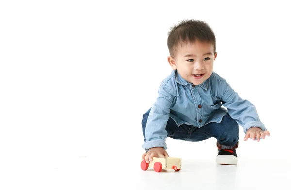 Yakışıklı giysili şirin Asyalı küçük bir çocuğun portresi. Bedava oynayarak mutlu poz veriyor. Çekici masum çocuk sağlıklı görünüyor, neşeli bir şekilde çocukluktan zevk alıyor, beyaz arka planda izole edilmiş..