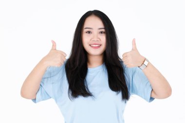 Asyalı genç tombul, tombul, uzun siyah saçlı, mavi günlük gömlek ve kol saati giyen, el ele tutuşan, beyaz arka plandaki kameraya gülümseyen, gülümseyen bir kadının yakın plan fotoğrafı..