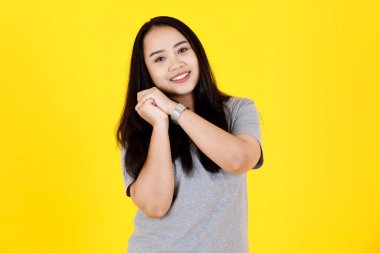 Asyalı, genç, güzel, tombul, şişman, uzun siyah saçlı, gündelik giyimli, el ele tutuşmuş bir kadın modelin portresi..