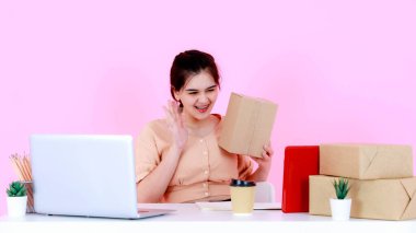 Asya 'nın mutlu, başarılı, başarılı, genç, profesyonel girişimci iş kadınının atölye çekimi. Merhaba, merhaba, güle güle, video çağrısı. Küresel internet müşterileri pembe arka planda..