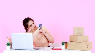 Asya 'nın mutlu, başarılı, başarılı, genç, profesyonel girişimci iş kadınının atölye çekimi. Merhaba, merhaba, güle güle, video çağrısı. Küresel internet müşterileri pembe arka planda..