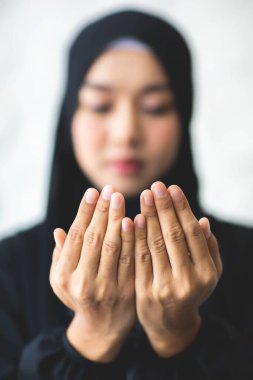 Asya 'lı güzel Müslüman kadının tesettürlü görüntüsünü yakınlaştır. Tanrı' ya inandığını gösteren dualar et..