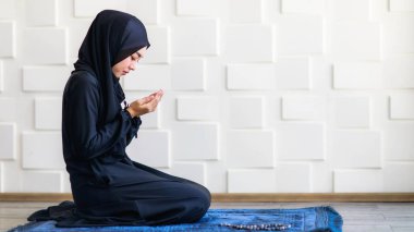 Gündüz tesettürlü Asyalı güzel Müslüman kadın Tanrı 'ya inandığını göstermek için dua et..