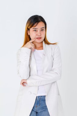 Asyalı modaya uygun kentsel güzel mutlu saç modelinin uzun bir takım elbise ve kot pantolon giymiş beyaz arka planda poz veren kameraya bakarken çekilmiş bir portre resmi..