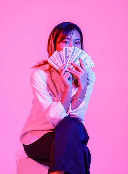 アジアの豊かな富の女性ビジネス女性モデルのポートレートスタジオショットカジュアルな着用で座っているカメラを見ますフル100ドルを保持します — ストック写真