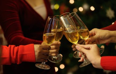 Mutlu ilişkinin tadını çıkaran neşeli kadın arkadaşlar tarafından Noel partisinde kadeh tokuşturulan içki kadehleri. Eski tarz resme uyması için biraz gürültü ekle.