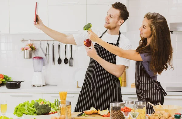 Cheerful Couple Aprons Apple Broccoli Hands Taking Self Portrait While — Stock Photo, Image