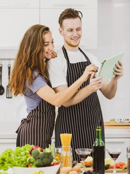 Contenido Pareja Delantales Surf Tableta Mientras Está Pie Mesa Con — Foto de Stock