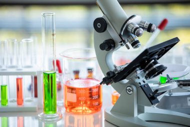 Bilimsel mikroskop ekipmanları ve kimyasal sıvı çözeltisi cam tüp içinde biyoloji numunesi ve ilaç testi için deney tüpü ve sağlık araştırmaları için kimya laboratuvarında tıbbi deney..