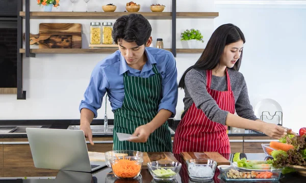 아시아 요리사 부부는 서로를도와 맛있는 유기농 야채로부터 샐러드를 접시에 요리하는 — 스톡 사진