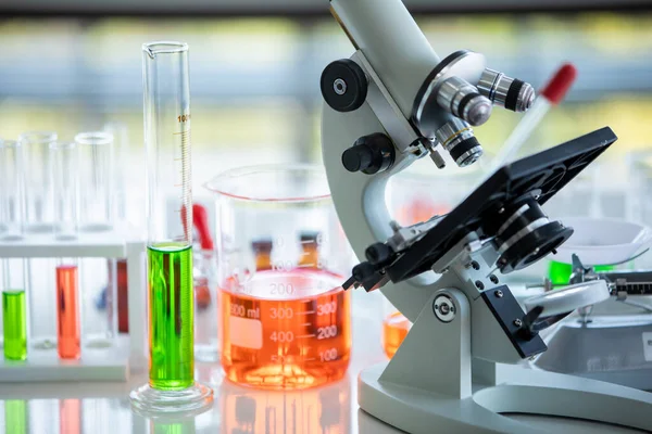 ガラス管内の生物試料としての科学顕微鏡装置及び化学液溶液 健康研究のための化学実験室での医薬品試験及び医学実験のためのビーカー — ストック写真