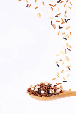 Çoklu tahıl, beyaz arka planda izole edilmiş ahşap kaşıkta fasulye sıçraması, Hareket, yiyecek ve içecek nesne tasarımı.