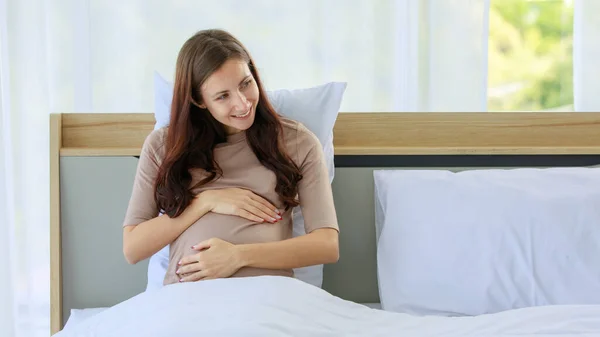 Beyaz Genç Mutlu Hamile Gündelik Gömlekli Bir Kadın Yatak Odasında — Stok fotoğraf