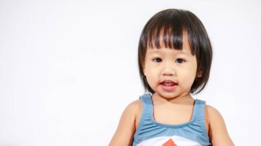 Beyaz arka planda oturan şirin gri köpek balığı kostümlü Asyalı küçük kız bebek modelinin stüdyo fotoğrafı.