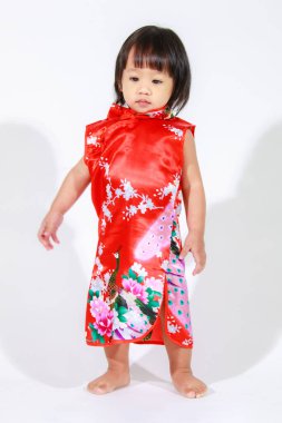 Asya 'da küçük şirin, masum, anaokulu anaokulu kızı kız çocuk kırmızı Çin geleneksel Qipao Cheongsam kıyafetiyle kısa siyah saç modeli beyaz arka planda tek başına duruyor..