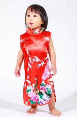 Asya 'da küçük şirin, masum, anaokulu anaokulu kızı kız çocuk kırmızı Çin geleneksel Qipao Cheongsam kıyafetiyle kısa siyah saç modeli beyaz arka planda tek başına duruyor..