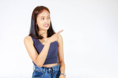 Kırpılmış bluz ve kot pantolonlu Asyalı genç kadın modelin boş alanda el ele tutuşup beyaz arka planda ürün reklamını gösterirken çekilmiş izole bir fotoğrafı..