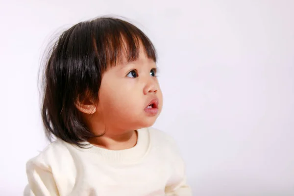 亚洲女婴穿着休闲格子花裙坐在白色背景上微笑的可爱短短的黑发模特演播室照片 — 图库照片