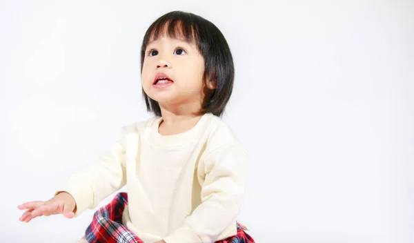 亚洲女婴穿着休闲格子花裙坐在白色背景上微笑的可爱短短的黑发模特演播室照片 — 图库照片