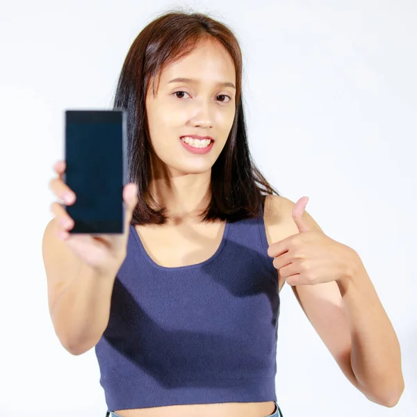 고립된 스튜디오에서는 배경에 스마트폰을 청바지를 생산하는 아시아인젊은 모델을 촬영했다 — 스톡 사진