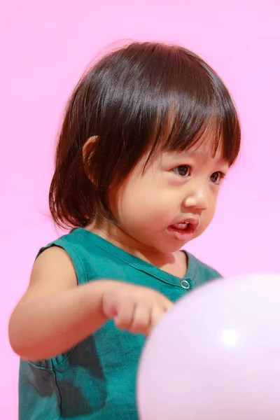 肖像工作室拍摄了一个可爱的亚洲幼稚园女模特儿 她穿着休闲装 带着粉色背景的彩色气球 — 图库照片
