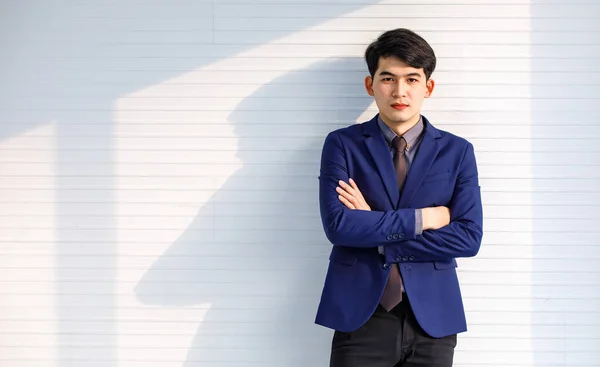 ポートレートスタジオショットのアジアのハンサムなプロの成功した男性実業家で正式な青いスーツネクタイ立っている交差腕笑顔見てのカメラで白いストライプの壁の背景 — ストック写真