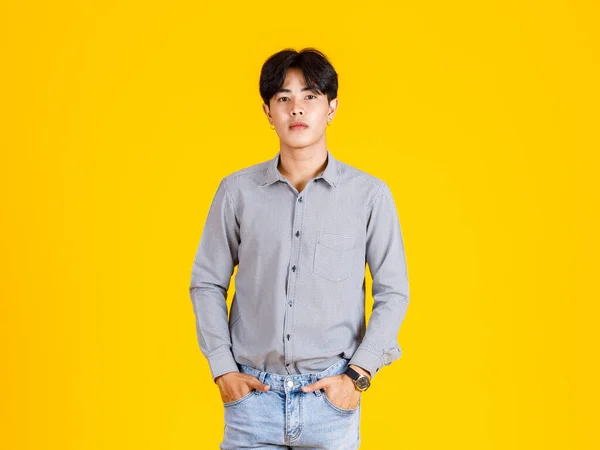 黄色の背景に立ってスタイリッシュなファッショナブルなカジュアルな服装で千年のアジアの若い男性ファッションモデルのスタジオショット — ストック写真