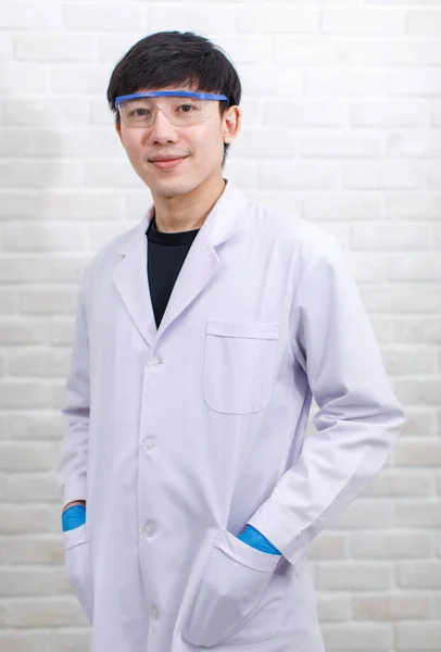 화실에서는 카메라를 웃으며 작업복을 아시아의 직업적 과학자를 촬영했다 — 스톡 사진