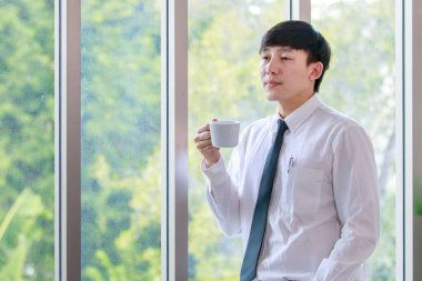 Yakışıklı ve zeki yönetici iş adamı, içki molası sırasında beynini rahatlatmak için bir fincan kahve içmeyi seviyor ve şirket ofisinde profesyonel yönetim için yaratıcı bir fikir düşünüyor..