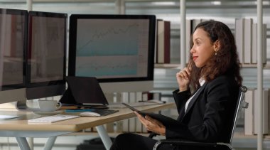 Afro-Amerikan profesyonel, başarılı, resmi takım elbiseli kadın iş kadını gülümseyerek oturuyor. Şirket bürosundaki müşteriyle çalışırken hedefin başarısına ulaşırken yumruğunu kaldırıp gülüyor..