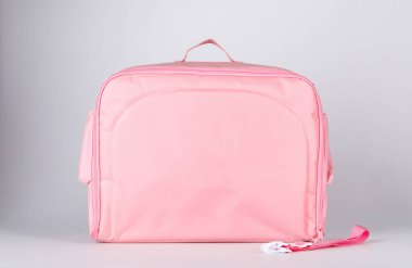 Temiz hijyenik lastik uçlu bebek süt şişesini sterilize ederken yakın çekim. Temiz plastik kapaklı. Pembe işlevli çok amaçlı fermuarlı kumaş torba kompartımanının içine yerleştirilmiş.