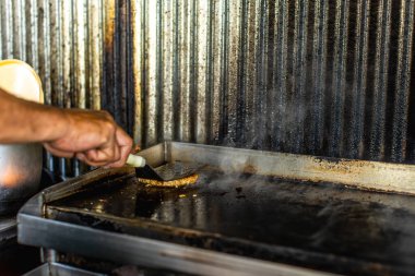 Tereyağlı taze pişmiş hamburgerin yakın plan çekimi, margarinli kıymalı kıyma ve domuz pastırması kirli, sağlıksız yerel restoran tezgahında tavada ızgara..