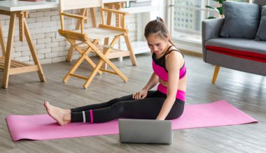 Asyalı, genç, güzel, seksi, zayıf, güçlü, spor kıyafetli, spor elbiseli, sırıtan, bacak bacak bacak üstüne atmış, kolları yoga pilatesinde serinleyen bir kadın model..