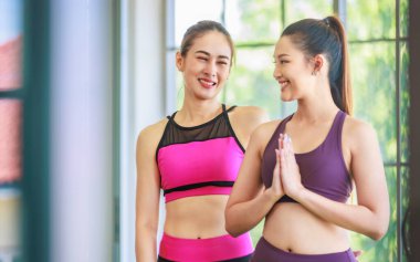 İki Milenyum Asyalı genç, sağlıklı, sağlıklı, güçlü, seksi, spor kıyafetleri içinde spor kıyafetleri giymiş, gülümseyen, göğüs kafesinde meditasyon yapan, pilates yoga salonu stüdyosunda çalışan kadın modeller..