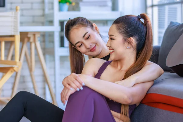 İki Milenyum Asyalı genç, güzel, sağlıklı, sağlıklı, güçlü, seksi, spor modelleri gündelik ürünler giyip spor kıyafetleri giyip salonda birlikte oturup, Safa 'da akustik gitarla sohbet ediyorlar..